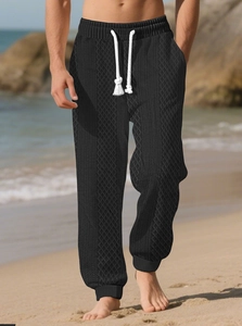 Détail du jogging jacquard noir avec texture en losange et cordons blancs pour homme