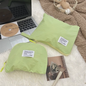 Close-up of light green waterproof travel pouches with zip closure on white rug
