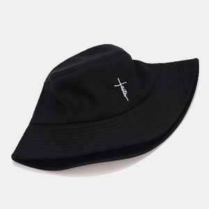 Black cotton bucket hat with white faith cross embroidery in a stylish street fashion look