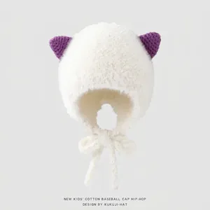 Dettaglio del cappello in peluche bianco con orecchie di gatto viola e laccetti antivento
