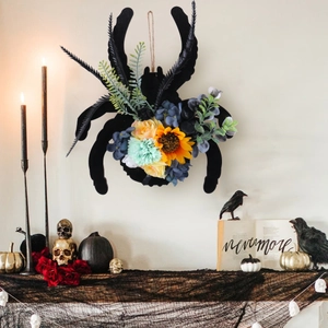 Couronne d'araignée d'Halloween avec fleurs colorées et verdure artificielle sur mur