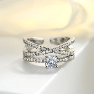 Macro shot of silver plated copper ring with triple-layer cross design and zircon stones