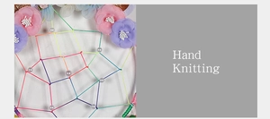 Detailed close-up of hand-knitted dream catcher with colorful fabric flowers and pearls