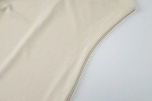 Détail de la robe d'été beige montrant la texture du tissu et les coutures de précision