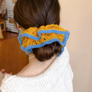 Close-up of dual-layer knitted flower hair scrunchie with yellow and blue crochet texture