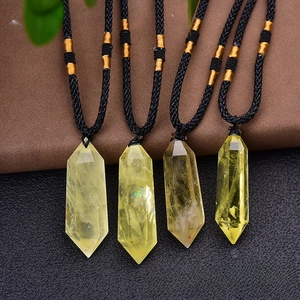 Macro shot of four yellow citrine hexagonal prism pendants with black braided cords