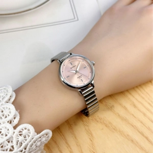 Elegant silver quartz watch with pink dial and stretch band on woman's wrist
