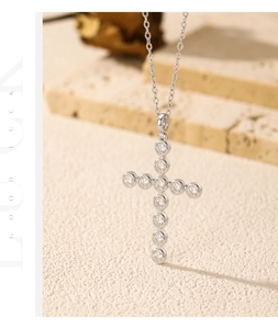 Detailed view of S925 silver cross pendant with VVS1 moissanite stones on beige stone
