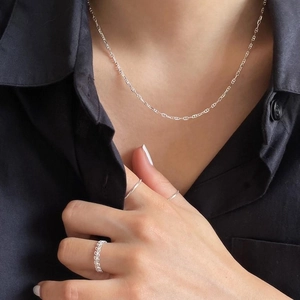 Silver 925 minimalist necklace and rings set displayed on a model wearing black