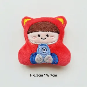 Détail de la texture peluche d'un pendentif brodé garçon cartoon de 6,5x7cm sur blanc