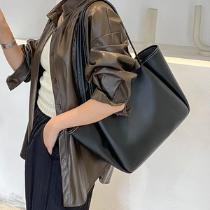 Minimalist large black leather tote bag with white contrast stitching for daily commute