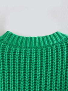 Dettaglio ravvicinato di maglione verde acceso a maglia grossa con girocollo a coste