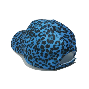 Detail view of leopard print baseball cap featuring blue fabric and adjustable strap back