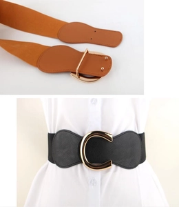 Detail view of vintage horseshoe buckle elastic waist belt in brown and black leather