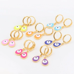 Close-up of six pairs of gold hoop earrings with colorful enamel devil eye pendants
