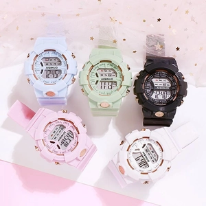 Vue de dessus de cinq montres de sport numériques en couleurs pastel sur un tulle doux