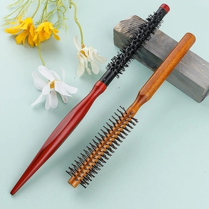 Lot de petites brosses rondes en bois pour le volume et la coiffure sur fond floral