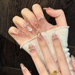 Faux ongles amande dégradé rose nude avec motifs léopard et nœuds argentés en relief