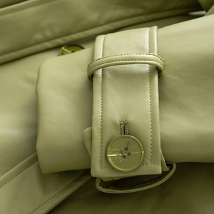 Close-up of olive green leather coat cuff featuring adjustable strap and matching button