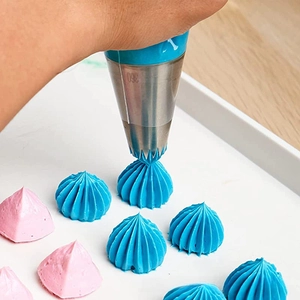 Dettaglio del beccuccio in acciaio 304 modello 360 che crea fiori di crema blu su torta