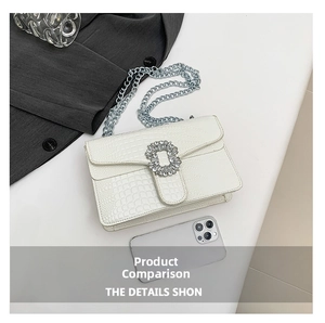 Detail of white crocodile pattern crossbody bag with rhinestone buckle and chain strap