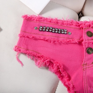 Dettaglio degli shorts in denim rosa acceso con doppia fila di strass e bordi sfilacciati