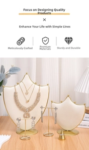 Detail of layered gold rhinestone necklaces and earrings set on a display stand