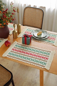 Detailed view of woven table runner with red and green geometric patterns and tassels