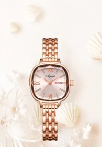 Détail macro de la montre rectangulaire pour femme en or rose avec date et bracelet métal