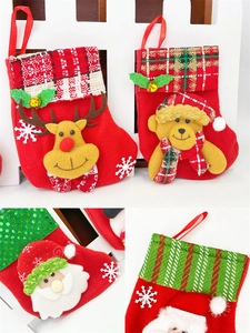 Detail of red felt Christmas stockings with plaid cuffs and 3D plush holiday characters
