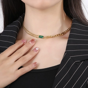 Close-up of model wearing a vintage gold chain with an emerald green square pendant
