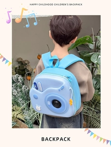 Zaino rigido blu a forma di fotocamera per bambini indossato da un bambino all'aperto