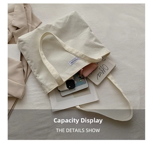 White corduroy tote bag showing large storage capacity for tablets and books
