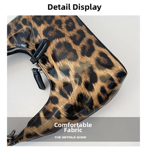 Close-up of shiny patent leather handbag with leopard print and smooth zipper detail