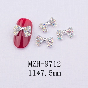 Vue macro des bijoux d'ongles nœuds argentés avec strass AB et dimensions 11x7,5mm