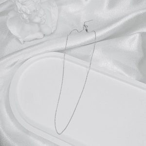 Detailed view of an S925 sterling silver ball chain necklace on a decorative white tray