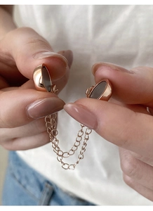 Macro shot of rose gold magnetic clip with double chains for T-shirt shortening and styling