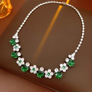 Macro detail of luxury flower necklace with emerald green and white zircons on leather