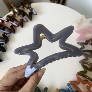 Detail shot of hollow star hair claws in various elegant Morandi colors and glossy finish