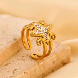 Detailopname van een 18K gouden sterring met pavé diamanten op een stenen achtergrond