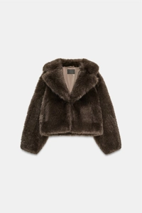 Détail d'un manteau en fausse fourrure marron foncé avec texture douce et revers