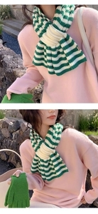 Detailed knit texture of green and white striped wool blend scarf for winter warmth