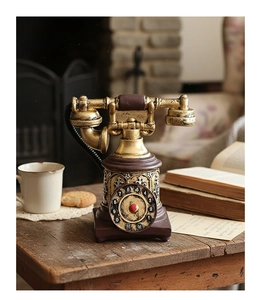 Detalle de teléfono retro de disco con acabado en bronce sobre mesa de madera