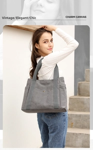 Detail view of large grey canvas tote bag with functional pockets and wide strap