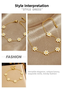 Detail of gold chain bracelet featuring six white daisy charms with yellow centers
