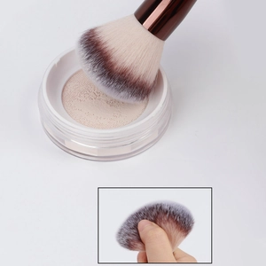 Detail of dual-ended makeup brush with soft bristles and elastic mesh powder container