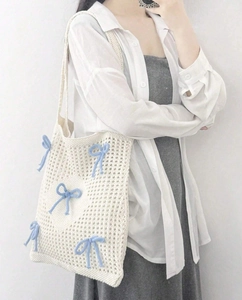 Detail of hand-woven cream tote bag featuring light blue ribbon bows and hollow knit pattern