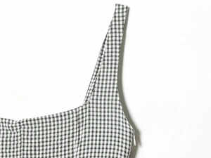 Gros plan sur une robe à carreaux noir et blanc avec coutures et fermeture éclair invisible