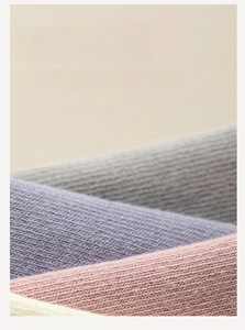 Macro detail of textured cotton yoga socks in gray, purple, pink, and beige tones