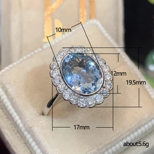 Elegant floral oval aquamarine zircon ring with silver halo and 45-degree jewelry box view